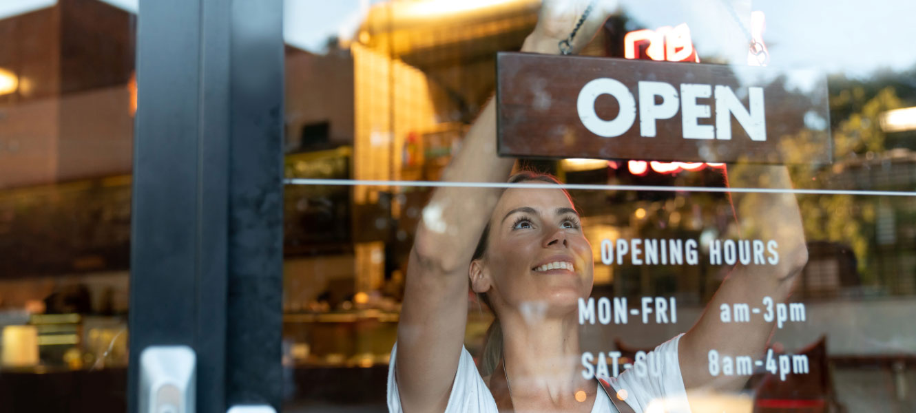 small business owner hanging up open sign