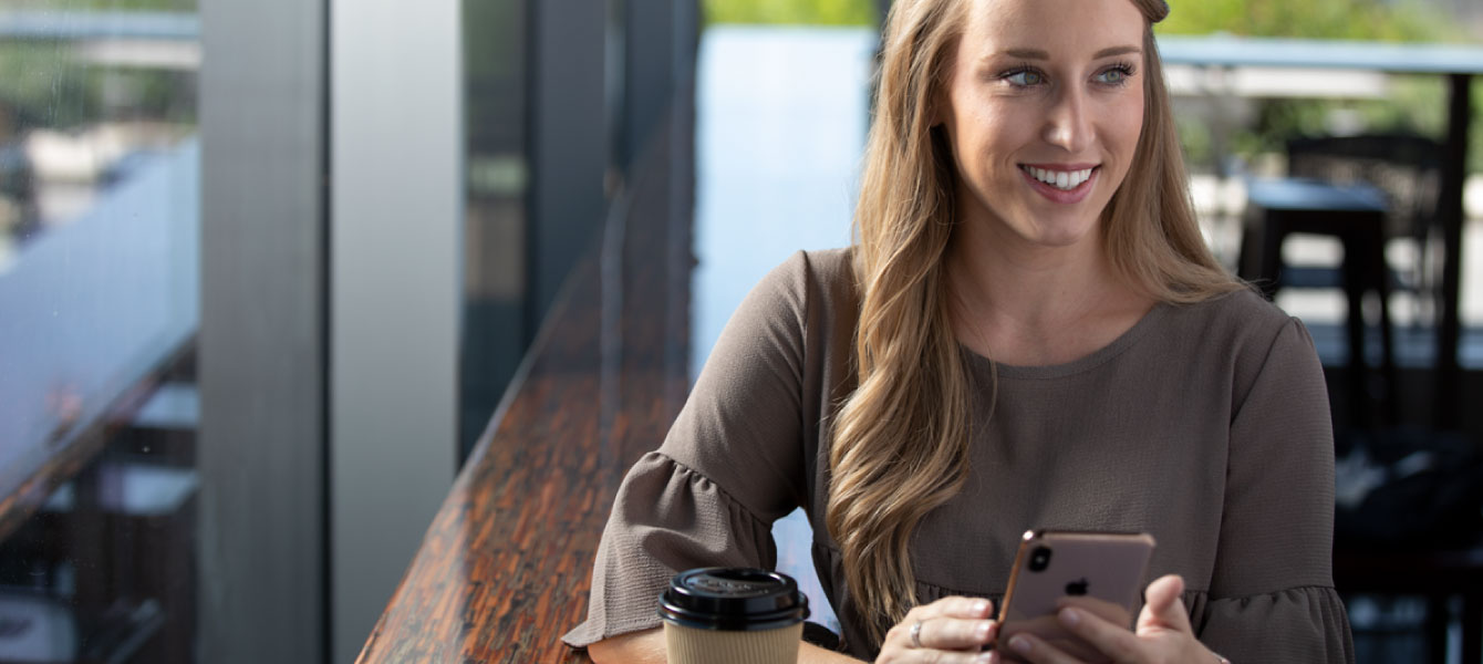 Woman using her phone at a coffee shop.