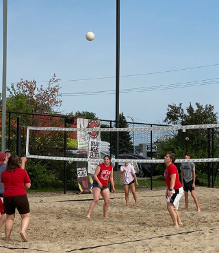Photo of employees participating in a company volleyball game.