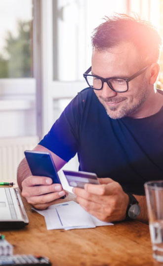 A man holding his phone and credit card.