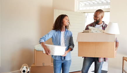 Husband and wife moving boxes into their new home financed by Access Bank.